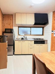 a kitchen with wooden cabinets and stainless steel appliances at はつはな in Osaka