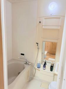 a bathroom with a bath tub and a mirror at はつはな in Osaka +7 photos