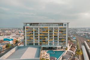 a large building with a pool in front of it at Ascent Premiere Hotel and Convention in Malang