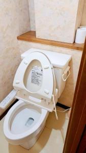a white toilet with its seat up in a bathroom at 烟雨轩 303 in Tokyo