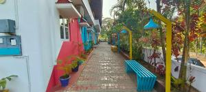 a cobblestone alley with benches and plants on a building at goSTOPS Coorg in Madikeri