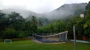 a volleyball net in a field with a mountain at Serene Blossom Valley in Tenkāsi