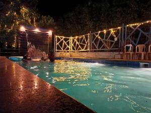 a pool with people in the water at night at Serene Blossom Valley in Tenkāsi