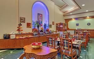 a dining room with wooden tables and chairs at Hotel Tamilnadu Rockfort Trichy in Tiruchirappalli