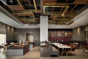 a restaurant with tables and chairs in a room at Ramada by Wyndham Sonipat Murthal in Sonīpat
