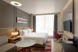 a hotel room with a bed and a tv at Ramada by Wyndham Sonipat Murthal in Sonīpat