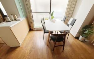 a dining room with a white table and chairs at 烟雨轩 303 in Tokyo