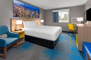 a bedroom with a bed and a desk and a chair at Days Inn by Wyndham Waukegan Great Lakes-Free Breakfast and Naval Base Shuttle in Waukegan +39 photos