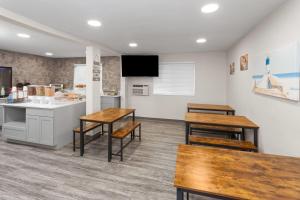 a kitchen with wooden tables and chairs in a room at Days Inn by Wyndham Waukegan Great Lakes-Free Breakfast and Naval Base Shuttle in Waukegan