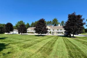 a large house with a large yard with green grass at Golden Gables Inn Dazzler Select by Wyndham in North Conway