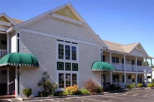a hotel with green awnings and a parking lot at Golden Gables Inn Dazzler Select by Wyndham in North Conway