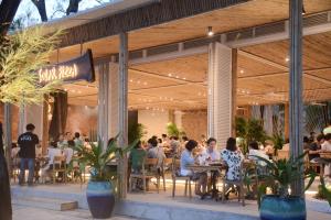 a group of people sitting at tables in a restaurant at LumiShora Villa - Bai Truong, Phu Quoc in Phú Quốc