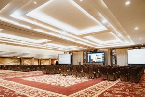 a conference room with chairs and a projection screen at Ascent Premiere Hotel and Convention in Malang +40 photos
