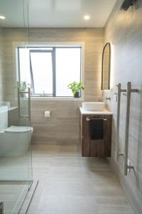 a bathroom with a sink and a toilet and a window at Murchison View house with Jacuzzi in Te Anau +4 photos