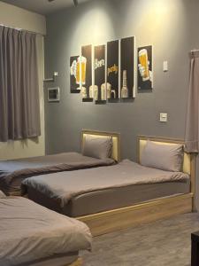 two beds in a room with posters on the wall at 鄉間旅人 自助入住 in Ta-pu-mei