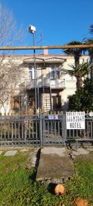 a fence in front of a house with a sign at Levani's GuestHouse in Zugdidi
