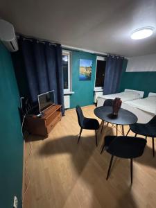 a living room with a bed and a table and chairs at Mieszkaj U Marty in Jaworzno