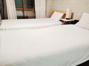 two beds sitting next to each other in a room at 烟雨轩 203 in Tokyo