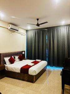 a bedroom with a bed and a window with curtains at Surabhi Comforts Inn in Mysore