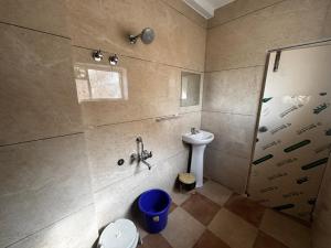 a bathroom with a shower and a toilet and a sink at Surabhi Comforts Inn in Mysore