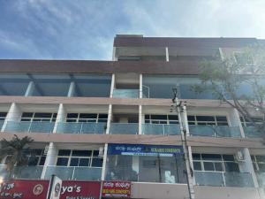 a building with a blue sign in front of it at Surabhi Comforts Inn in Mysore +5 photos