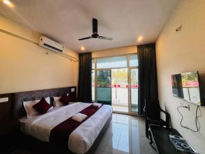 a bedroom with a large bed with a ceiling fan at Surabhi Comforts Inn in Mysore