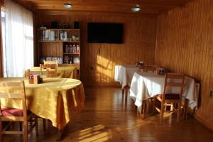 a dining room with two tables and a flat screen tv at Casa Lucy in Puerto Natales