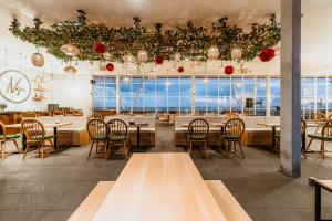 a restaurant with tables and chairs and a large window at Ascent Premiere Hotel and Convention in Malang