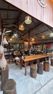 a large room with a large wooden table and benches at BaanRaiChayKhaoFarmStay in Nakhon Si Thammarat
