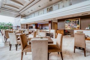 a restaurant with tables and chairs and a bar at Ascent Premiere Hotel and Convention in Malang