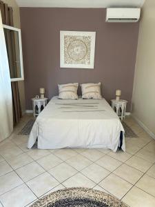 a bedroom with a large bed with two tables at A La Maison De Nani in Saint-Paul