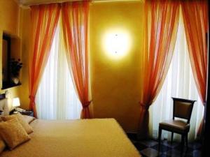 1 dormitorio con 1 cama, 2 ventanas y 1 silla en Camere D'Autore La Poesia en Monterosso al Mare