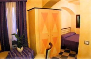 a bedroom with a bed and a cabinet with a plant at Camere D'Autore La Poesia in Monterosso al Mare