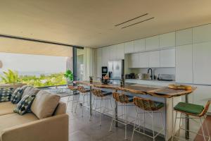 a kitchen and living room with a large island with bar stools at The View Mauritius in Ruisseau Créole
