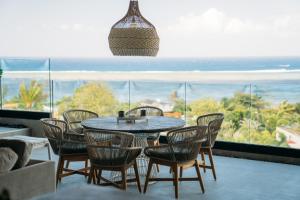 a table and chairs in a room with a view of the ocean at The View Mauritius in Ruisseau Créole +42 photos