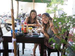 two women sitting at a table eating food at Fireworks Homestay in Hoi An