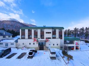 a large building with cars parked in the snow at Hotel Sol at Lake Toya in Lake Toya