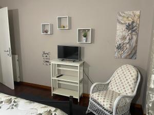 a living room with a tv and a chair at Casa Luna in Pomezia