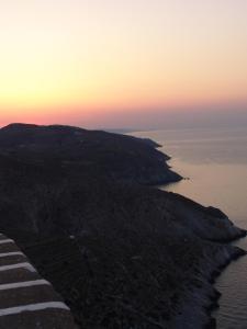 an island in the ocean at sunset at Anima Apartments in Chora Folegandros