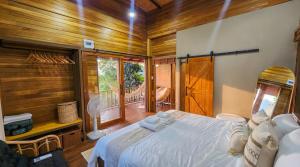 a bedroom with a white bed and a balcony at Epic Views Cabins - Ocean or Mountains, your choice in Ko Phangan