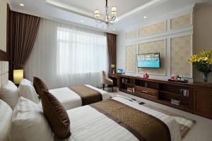 a hotel room with two beds and a flat screen tv at Center Hotel Bac Ninh in Bắc Ninh