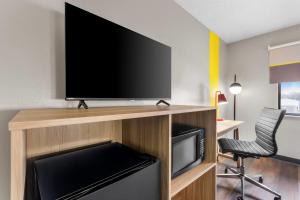 a flat screen tv sitting on top of a wooden entertainment center at Super 8 by Wyndham Evansville East in Evansville