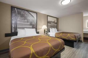 a hotel room with two beds and a staircase at Super 8 by Wyndham Macon West in Macon