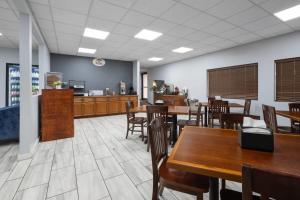 a dining room with wooden tables and chairs at Super 8 by Wyndham Macon West in Macon