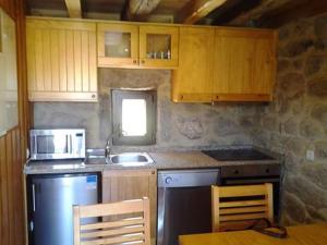 una cucina con mobili in legno, un lavello e una stufa di Casa da Corga a Portela