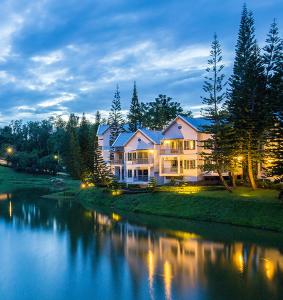 a large house sitting on the side of a river at Brookside Valley Resort in Rayong