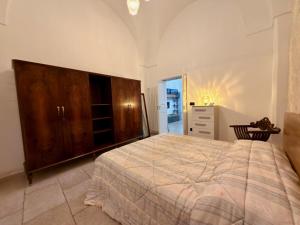 a bedroom with a large bed and a dresser at Dimora Imperiali in Francavilla Fontana