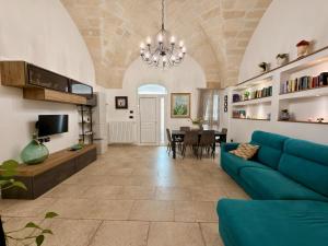 a living room with a blue couch and a table at Dimora Imperiali in Francavilla Fontana