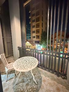a table and chair on a balcony with a view of a city at The Ray Hotel & Apartments in Phnom Penh