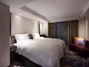 台北市にある在家行旅 西門館のベッドルーム(白い大型ベッド1台、赤いソファ付)